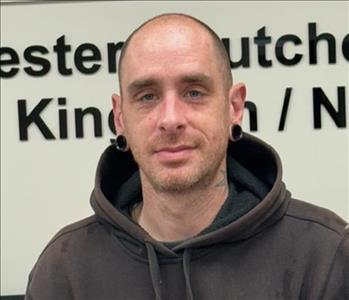 A photo of a smiling male employee wearing a black SERVPRO sweatshirt.