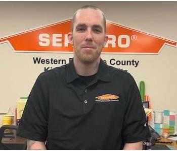 A photo of a male employee wearing a black SERVPRO shirt.