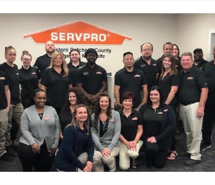 22 people wearing black SERVPRO shirts posing for a company photo