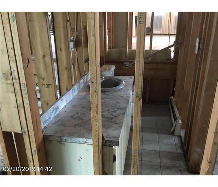 A bathroom in a home with water damaged walls taken down to the studs.