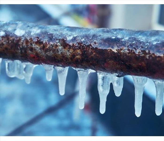 A photo of a piece of pipe with ice formed on it
