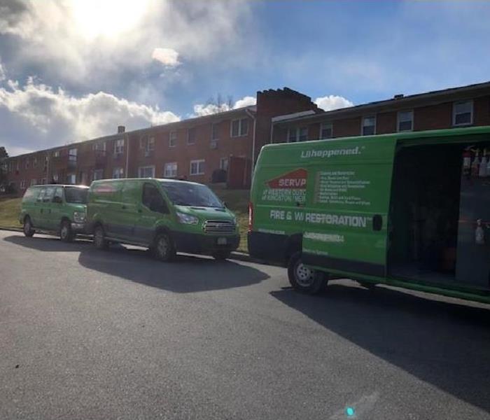 3 SERVPRO green trucks parked at a multi unit townhome community.