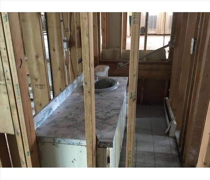 A bathroom in a home with water damaged walls taken down to the studs.