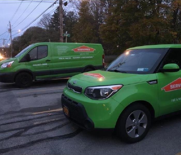 2 SERVPRO green vehicles parked at a residential damage early in the morning.