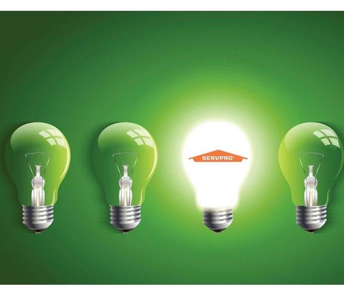 An image of 4 lightbulbs on a green background, the 3rd being lit up with the SERVPRO logo on it and the rest unlit.