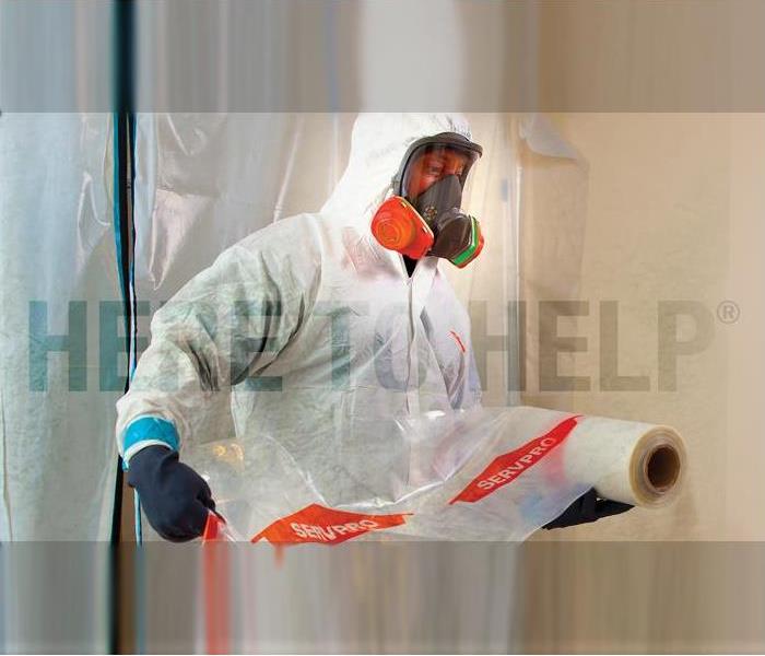 a SERVPRO employee in white PPE prepping an area for cleaning